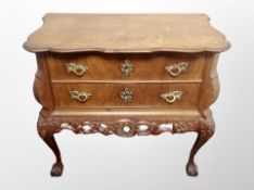 An early 20th century Danish carved walnut two drawer serpentine fronted chest on claw and ball