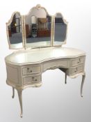 A cream and gilt kidney shaped mirror backed dressing table,