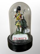 A Dewar's Scotch whisky advertising figure under glass dome,