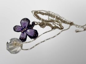 A crystal drop pendant on white metal chain and a further enamelled butterfly pendant on chain