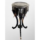 An Indian ebonised jardiniere stand carved with elephant supports,