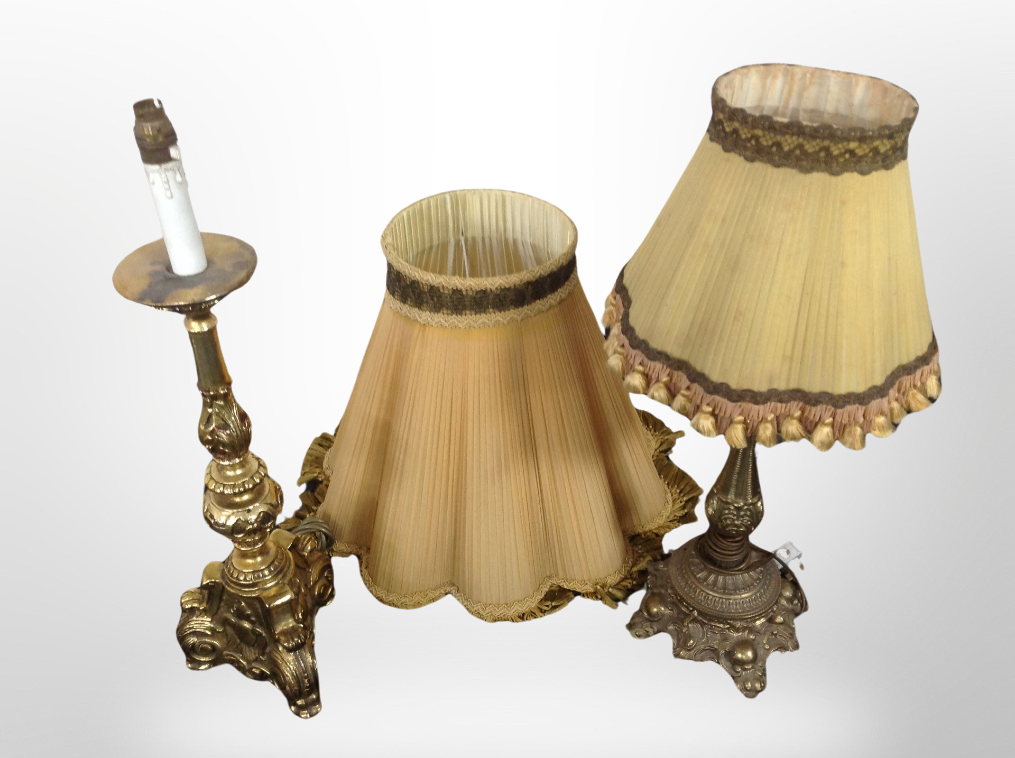 An ornate brass table lamp with tasseled shade and further gilt gesso lamp