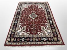 A Persian style woolen rug on red ground,