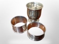 A silver egg cup and two napkin rings