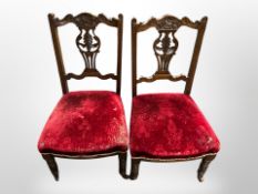 A pair of late Victorian carved salon armchairs in red velvet
