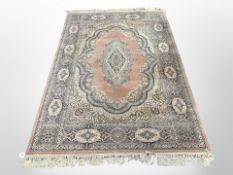 A machine made Persian design rug, on pink ground,