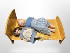 A wooden crib and two vintage dolls