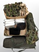 Two boxes of army camouflage hats, military camping beds in carry bags,