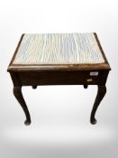 An Edwardian storage piano stool,
