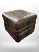A brown leather cube footstool,