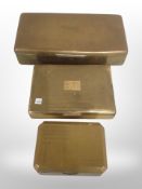 Three brass cigarette boxes, largest 25 cm wide.