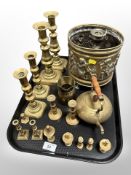 An embossed brass jardiniere on paw feet decorated with cherubs, three pairs of brass candlesticks,