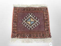 A small Iranian woolen rug 63 cm x 60 cm