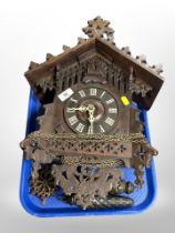 A Black Forest carved oak cuckoo clock with pendulum and weights