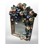 A decorative plaster wall mirror decorated with fruit,