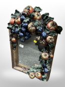 A decorative plaster wall mirror decorated with fruit,