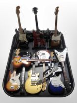A collection of miniature electric guitars on stands