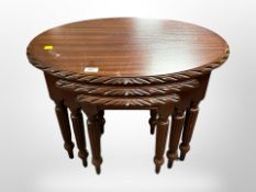 A reproduction mahogany oval nest of three tables,