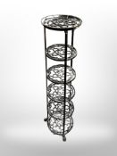 A cast metal six tier pan stand on paw feet,