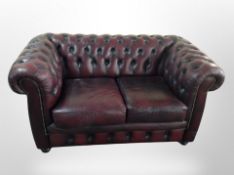 A Chesterfield oxblood buttoned leather two seater settee,