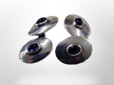 A pair of silver cufflinks inset with navy blue cabochon stones