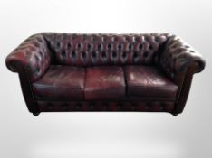 A Chesterfield oxblood buttoned leather three seater settee,