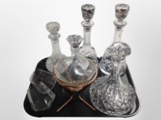 Five decanters including octagonal example on copper stand,