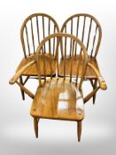 A stained beech spindle backed armchair and a further pair of single chairs