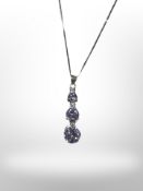 A silver drop pendant on chain set with violet coloured stones