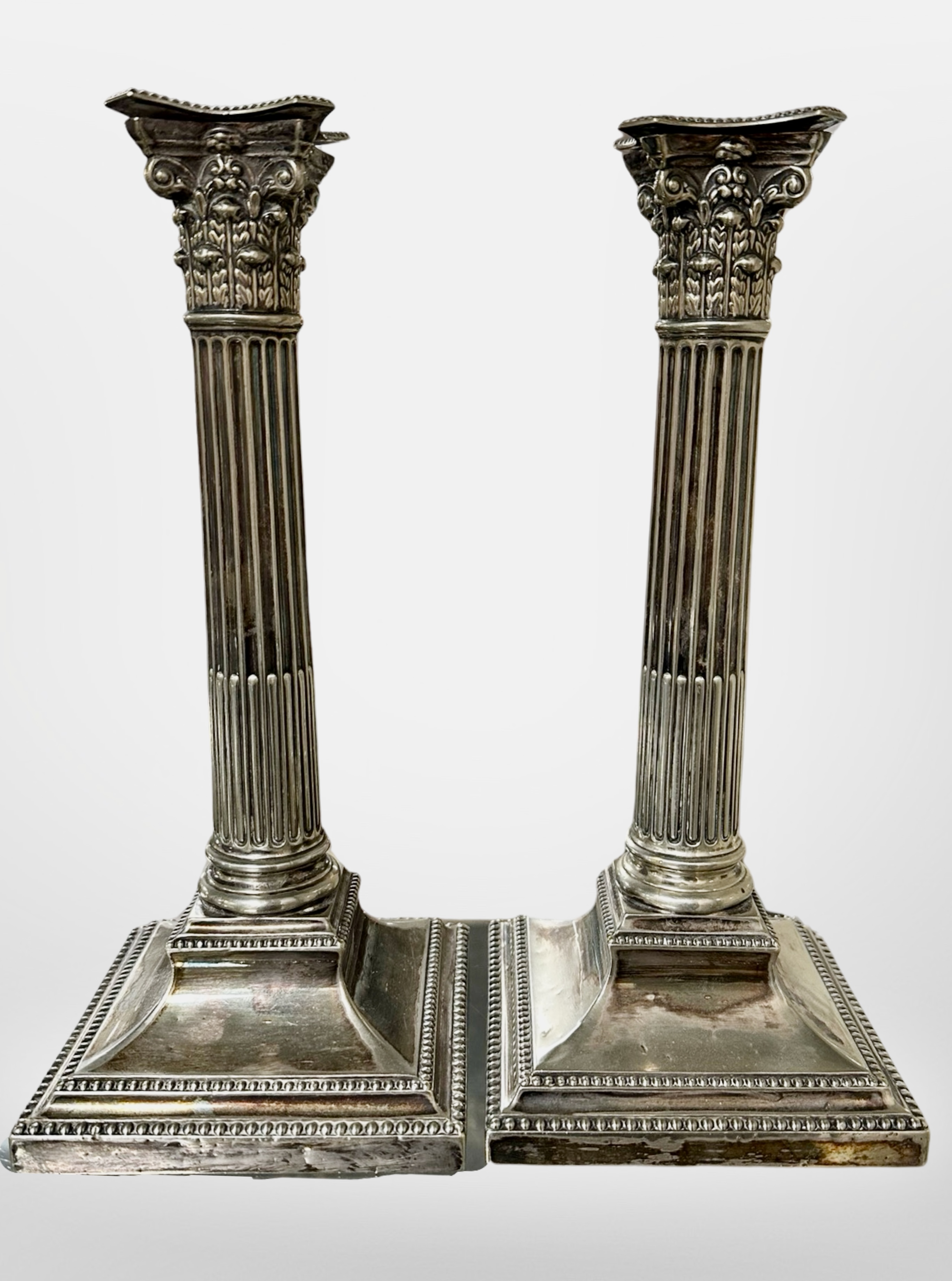 A pair of Walker & Hall silver-plated Corinthian column candlesticks,