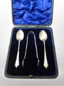 A pair of silver spoons with matching tongs in fitted case