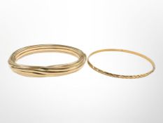 A 9ct yellow gold bangle with metal core, together with a Continental yellow metal bangle.