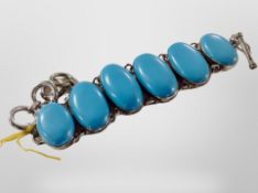 A silver bracelet set with large graduated turquoise cabochons,