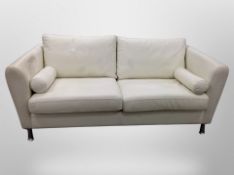 A contemporary cream leather two seater settee on metal legs with bolster cushions,