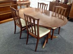 A reproduction mahogany extending table with leaf and four dining chairs
