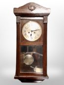 An early 20th century eight day wall clock with silvered dial