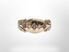 An antique yellow gold ring set with three rubies and diamond chips, size O.