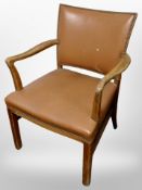 A beech armchair in studded tan vinyl upholstery,