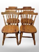 A set of four pine spindle backed dining chairs