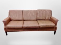 A late 20th century Danish brown leather three piece lounge suite comprising of three seater settee,