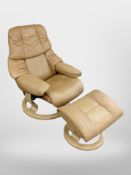 A tan leather swivel armchair with matching footstool