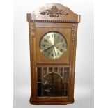 An oak eight day wall clock with brass dial
