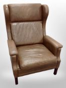A late 20th century Danish brown leather wing back armchair,