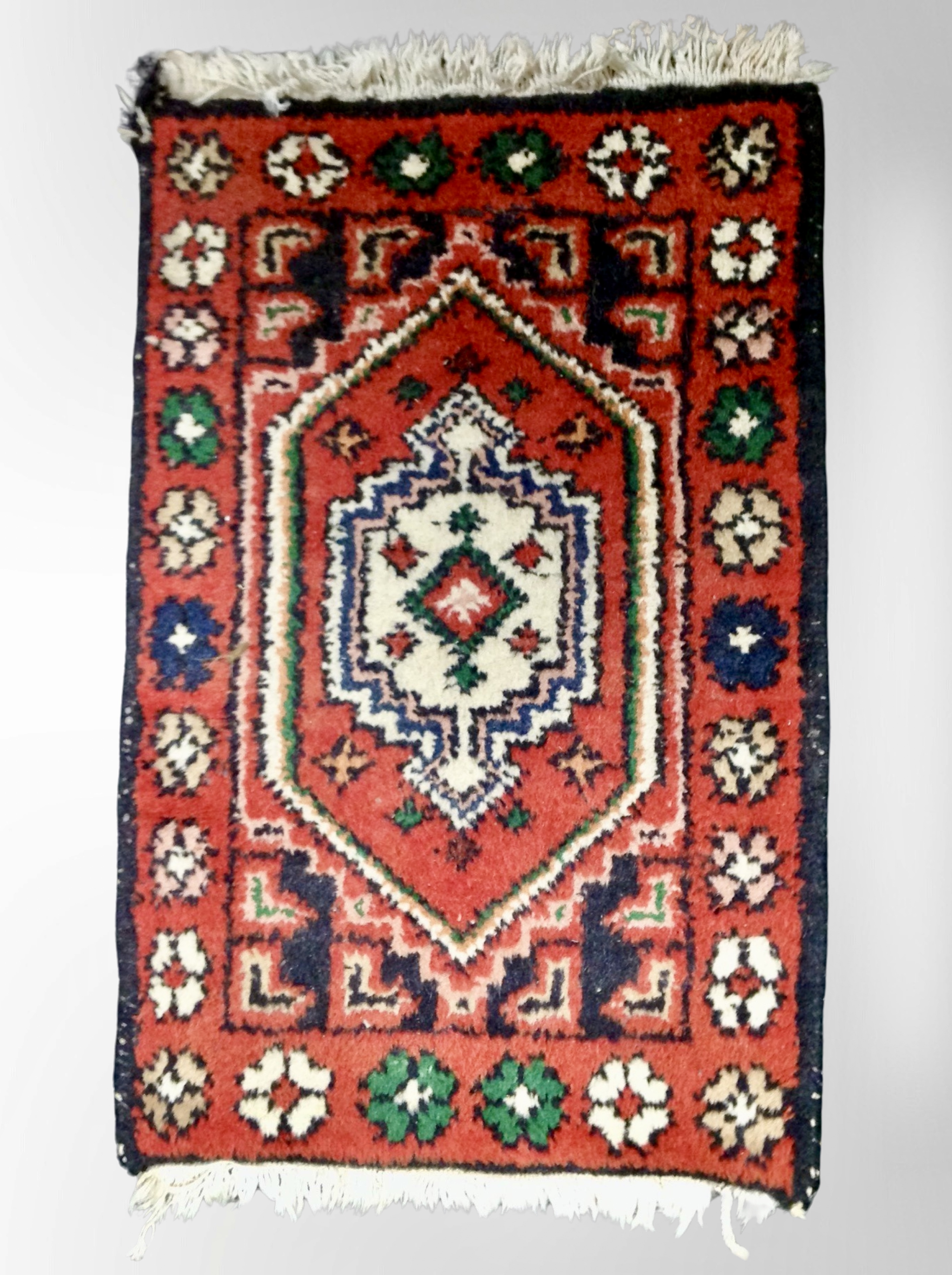 A small Iranian fringed rug 67 cm x 42 cm