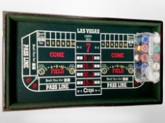 A Craps board and a quantity of casino chips and playing cards,