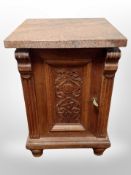 A 19th century carved oak pot cupboard with later granite top,