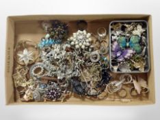 A shallow tray containing costume jewellery, rings, brooches,