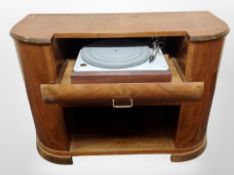 An Art Deco style figured walnut bow fronted record cabinet containing Bang & Olufsen turn table,