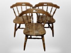 A set of seven stained beech spindle backed elbow chairs