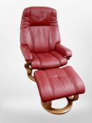 A red stitched leather relaxer armchair with matching footstool